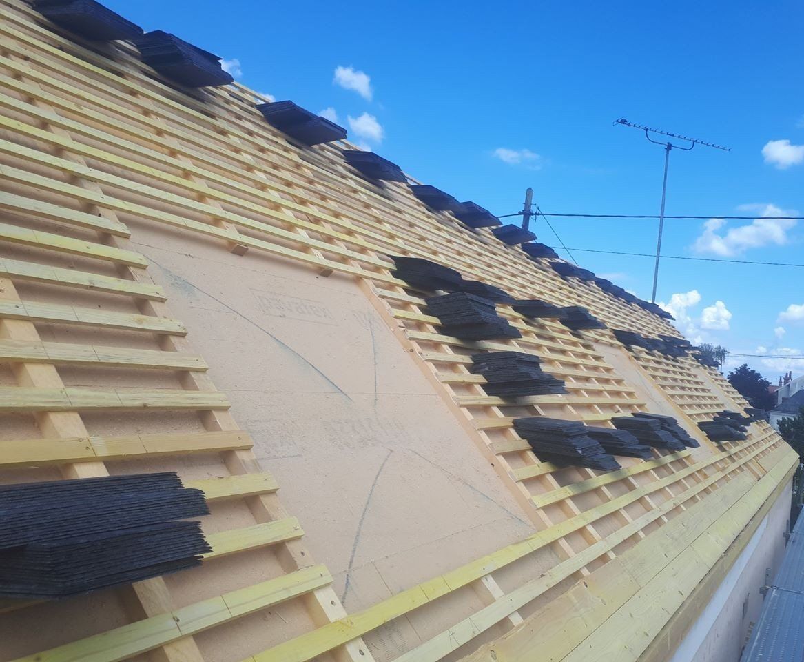 Toiture en ardoise en cours de montage avec l'isolation de couverture et la structure en bois