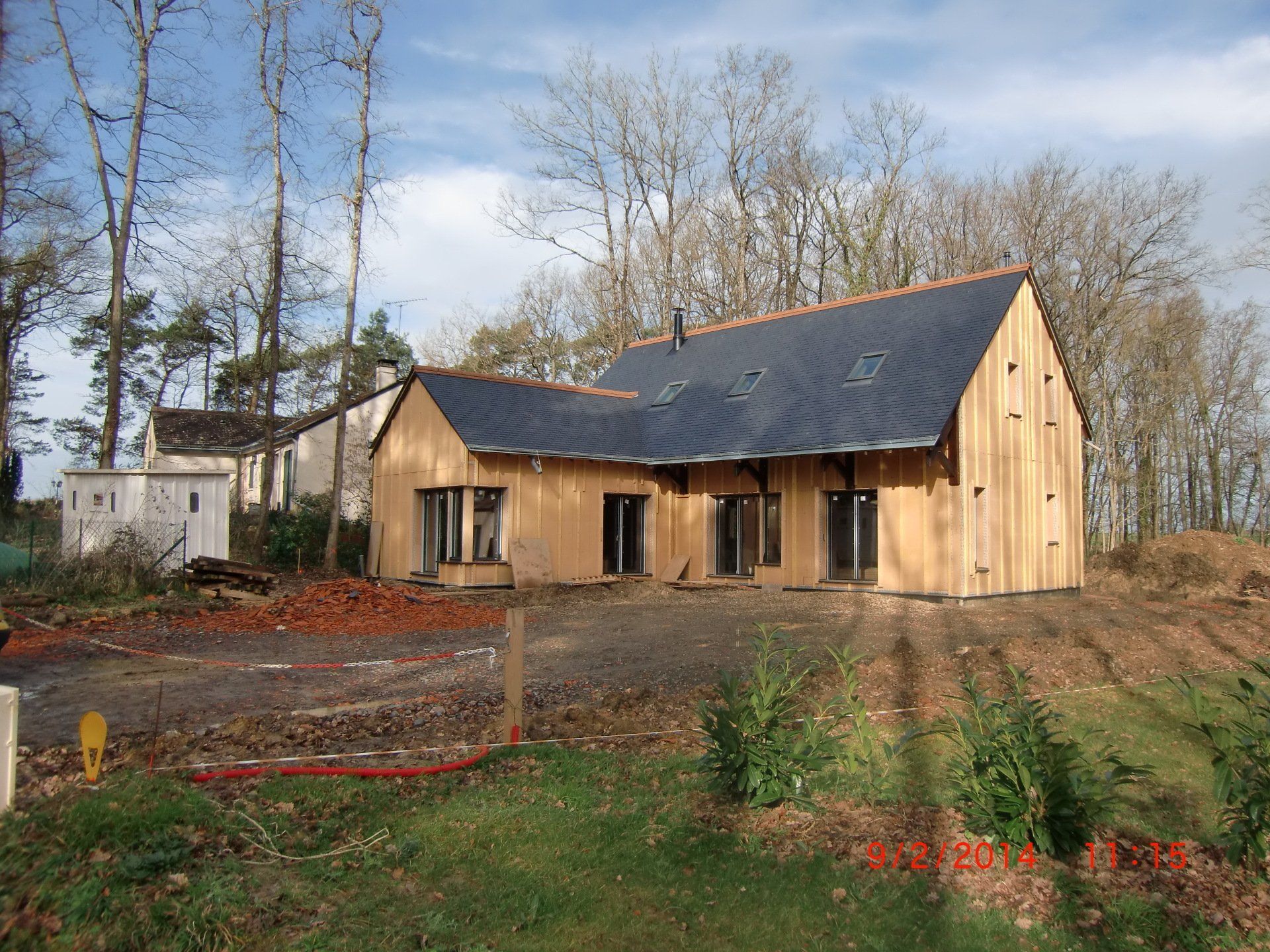 Maison en forme de L et en ossature bois avec trois fenêtres de toit