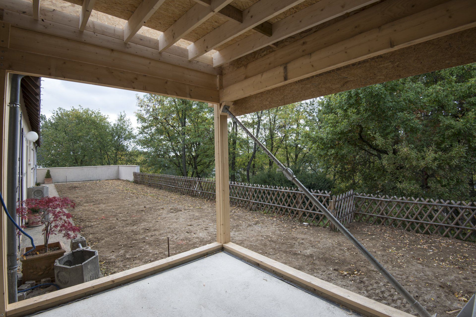 Construction d'une grande baie vitrée en angle avec vue extérieure sur la terrasse en bois