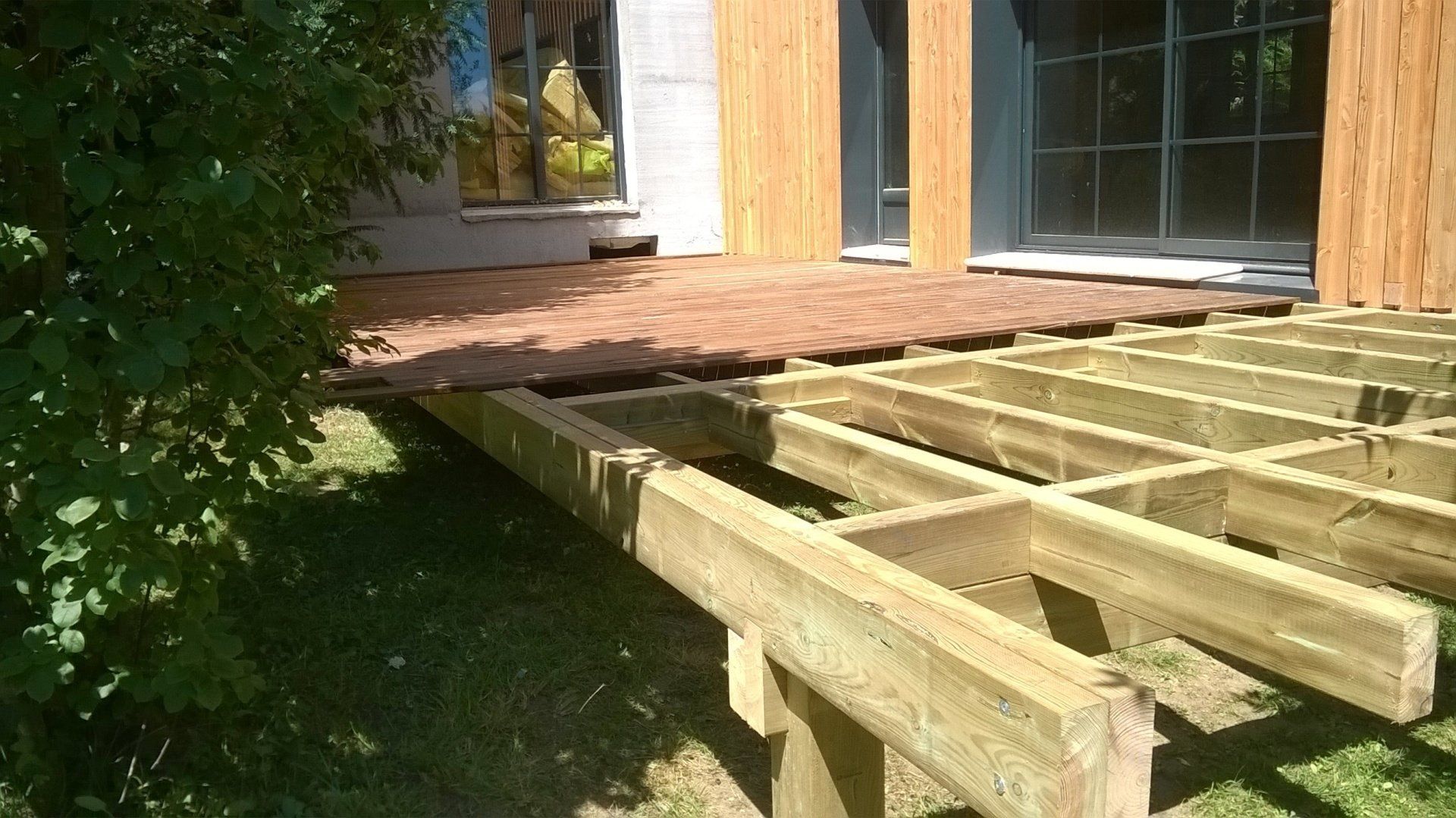 Terrasse en bois en train d'être construite avec une structure en bois en dessous