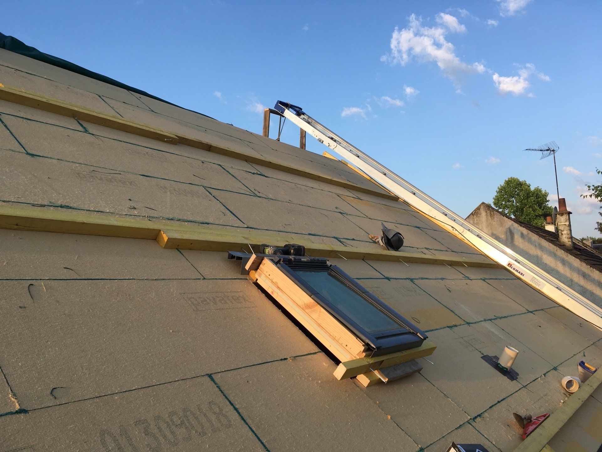 Gros plan sur une isolation de couverture avec une fenêtre de toit en premier plan