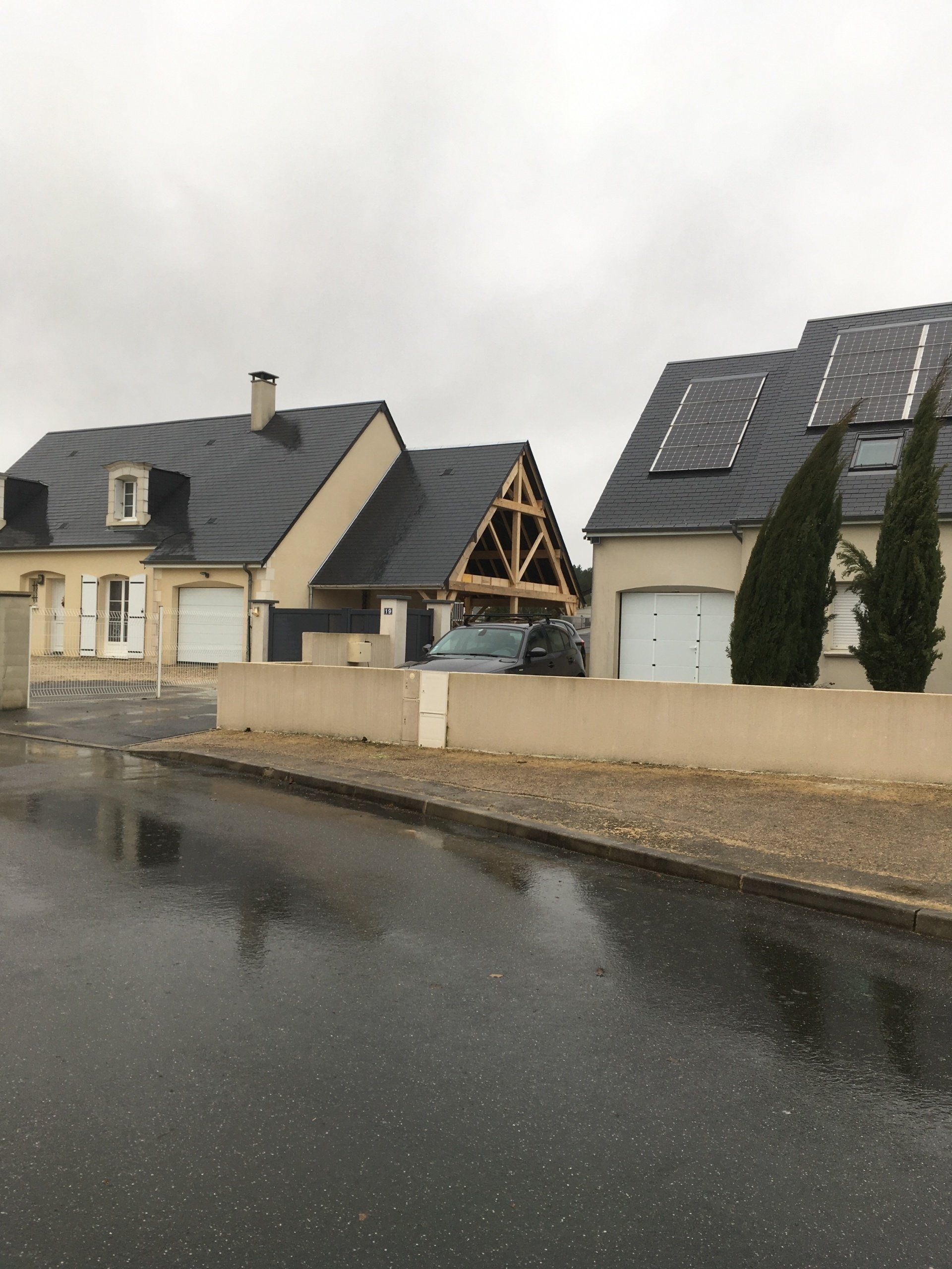 Quartier résidentiel avec deux maisons aux toitures en ardoise dont l'une possède des panneaux solaires 