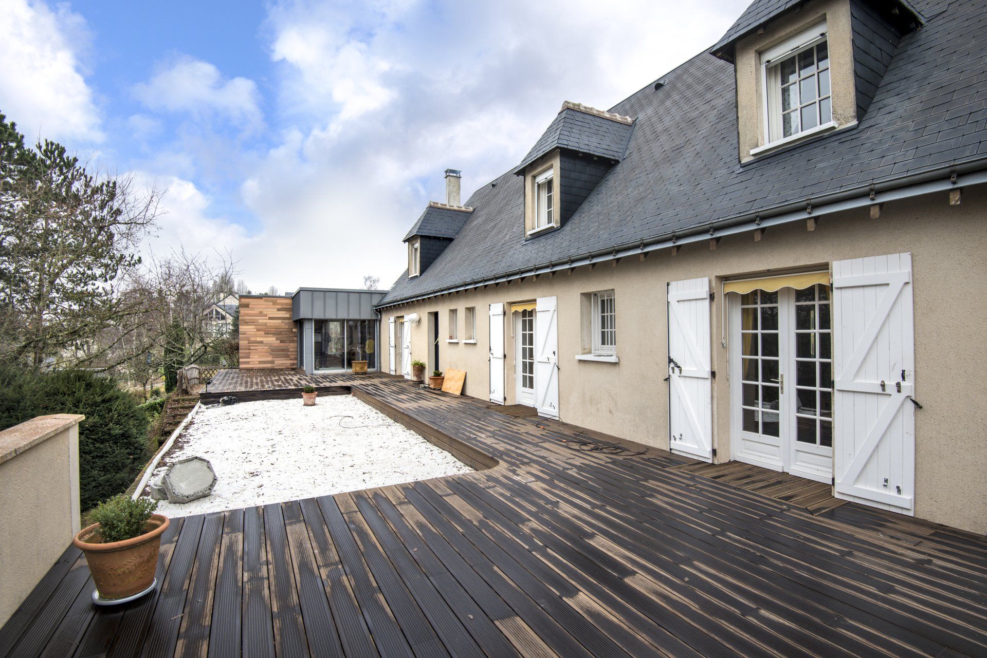 Aménagement extérieur avec terrasse bois, piscine enterrée et façade à baies vitrées – chantier LC²