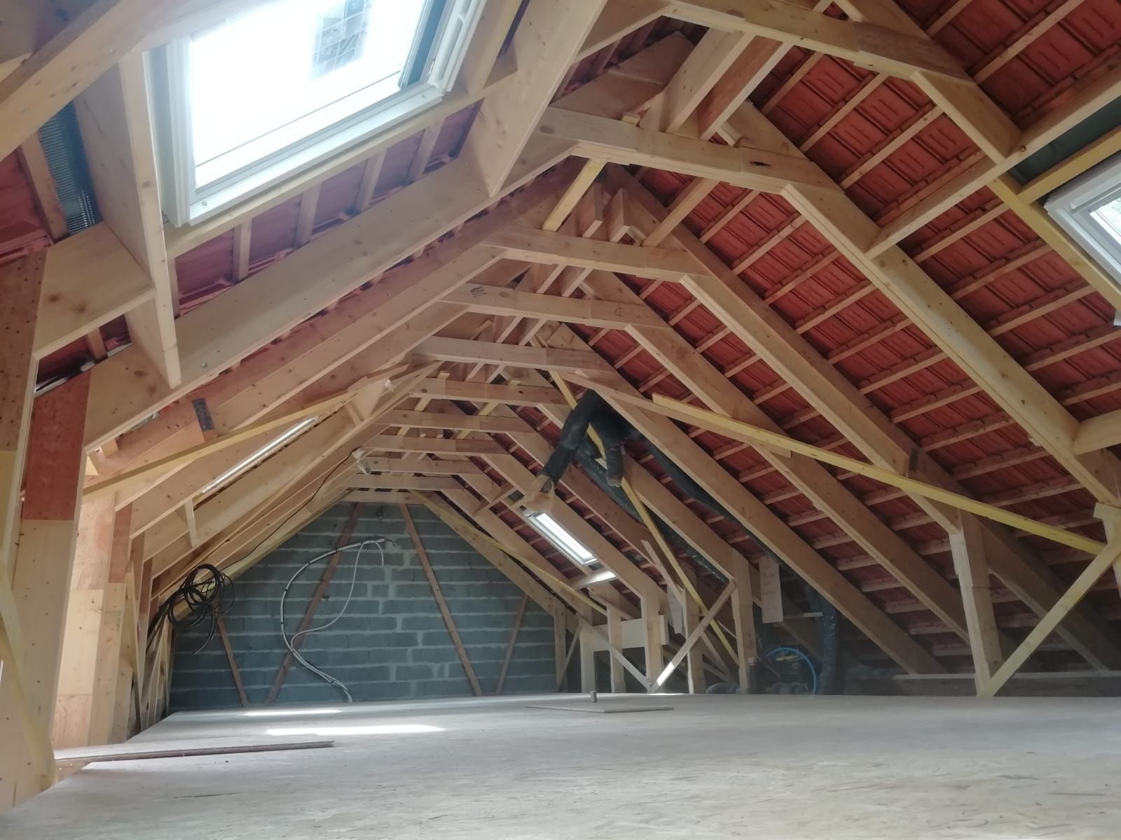 Vue intérieure d'une charpente terminée avec la couverture et les fenêtres de toit