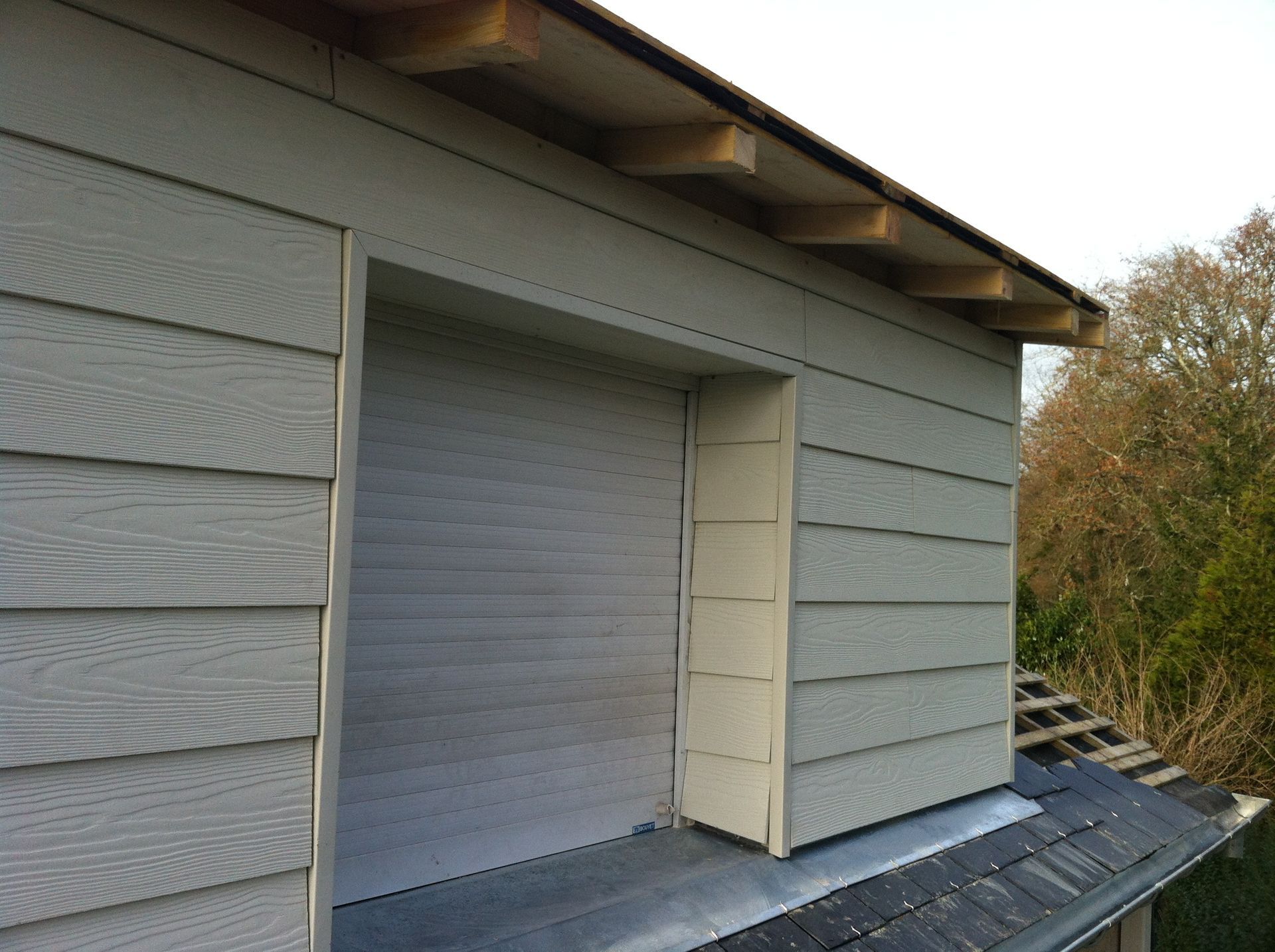 Fenêtre d'une maison avec bardage bois blanc cassé autour