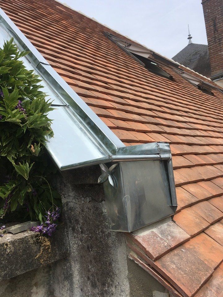 Gros plan sur un système de gouttières en métal au coin d'une toiture