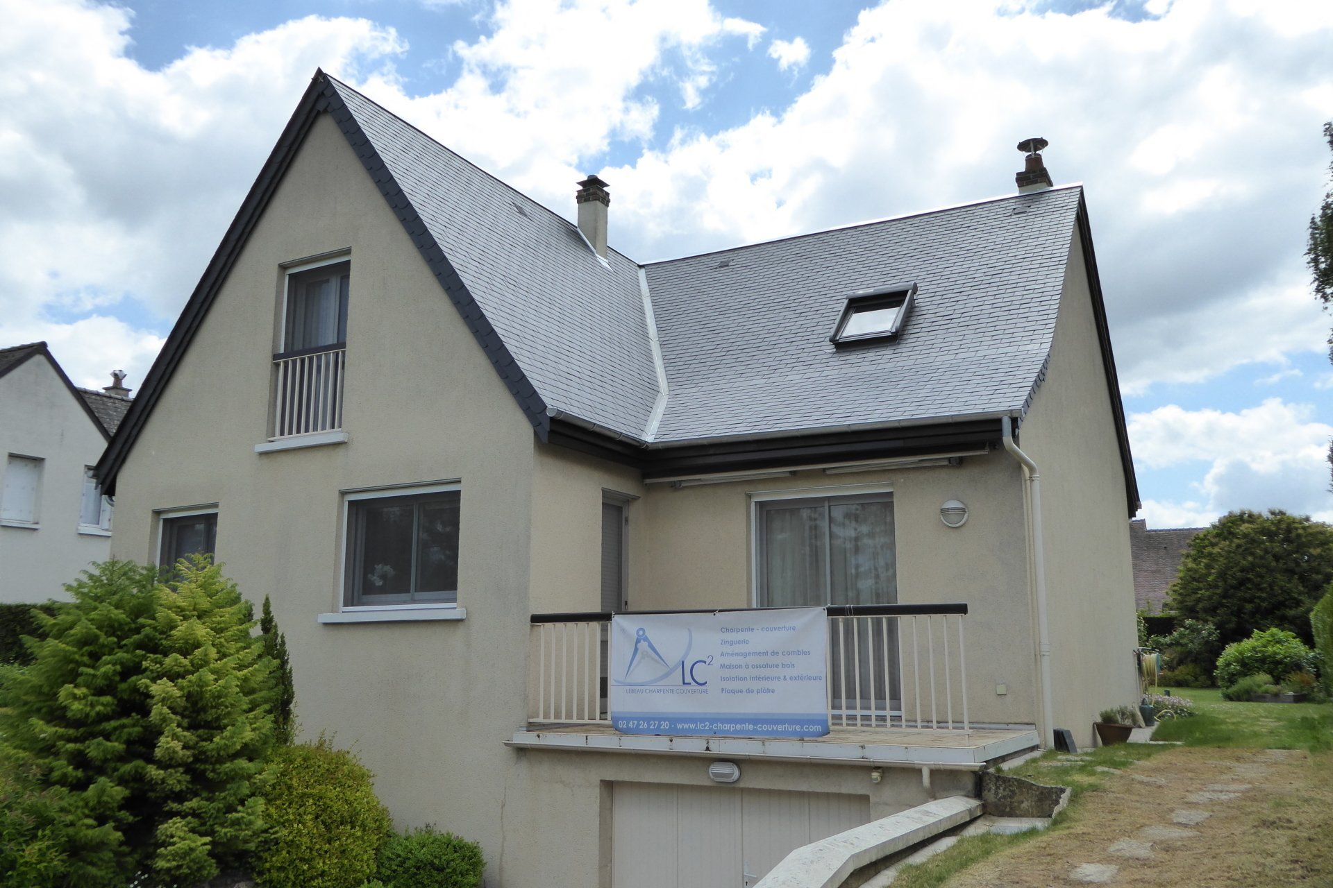 Maison avec une toiture rénovée et une banderole LC²
