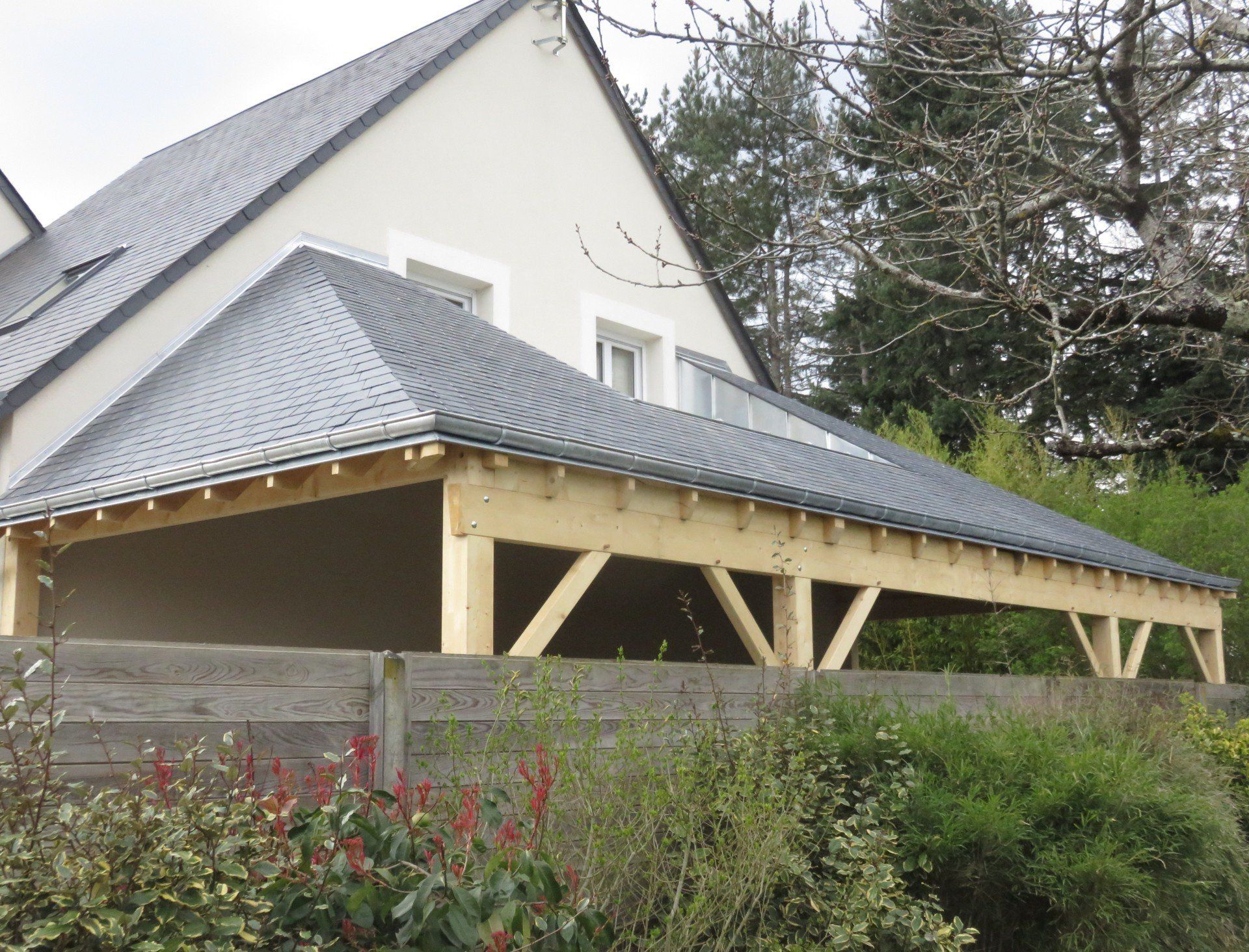 Couverture en ardoise d'un carport percée par deux fenêtres murales 