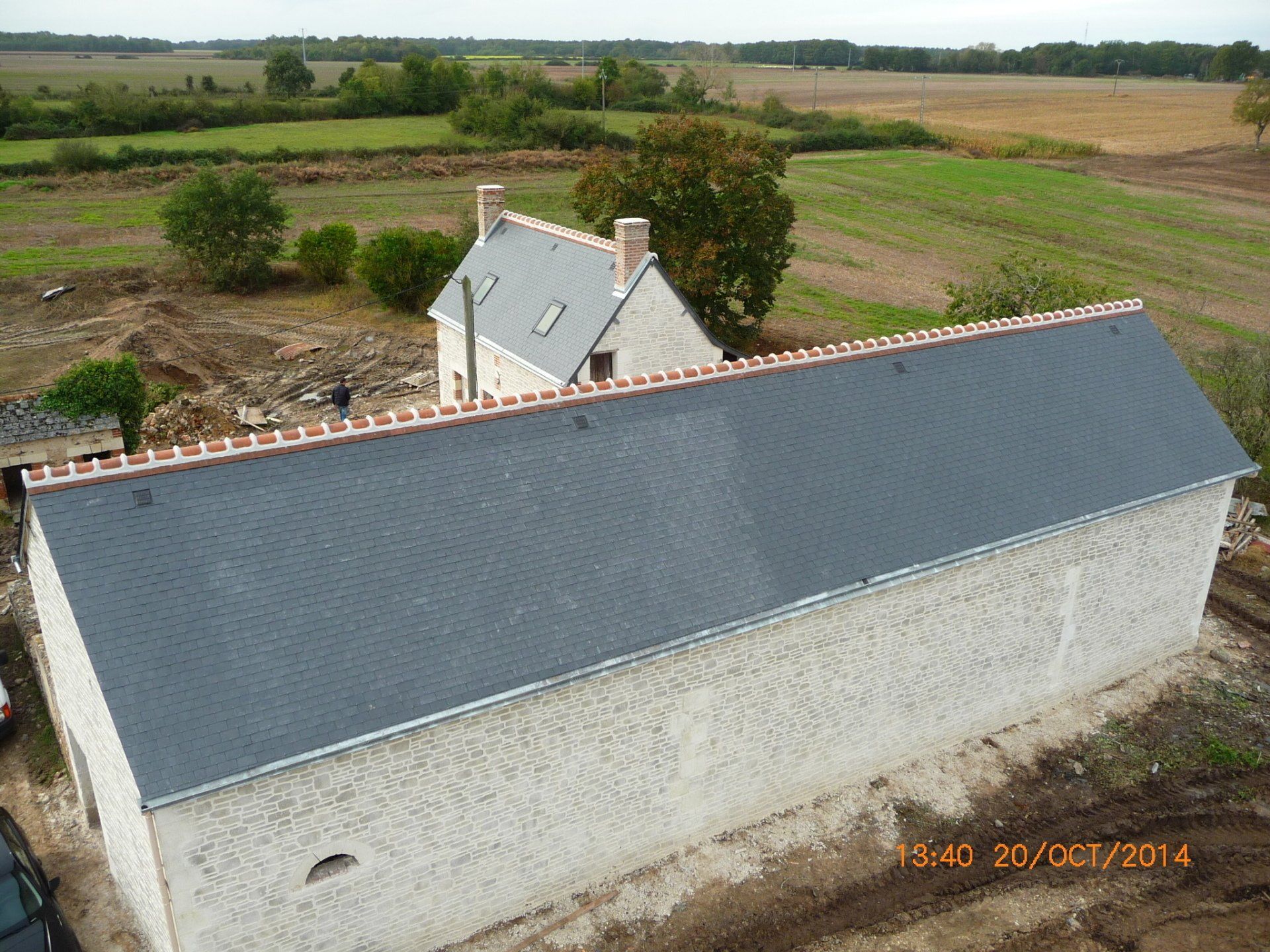 Vue drône d'une toiture rénovée en ardoise d'un bâtiment en longueur