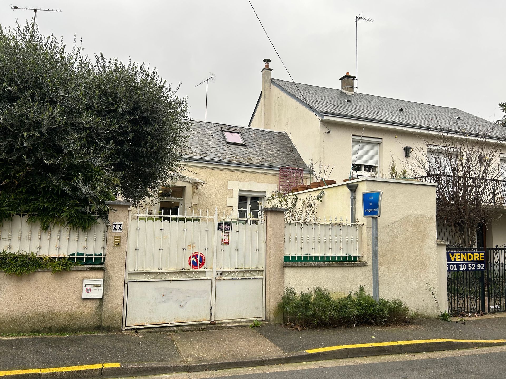 Deux maisons accolées avec un portail blanc