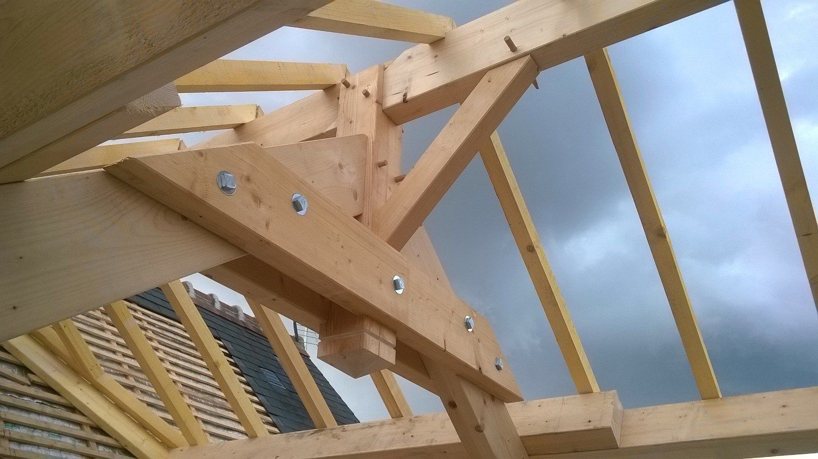 Gros plan sur l'angle de la ferme d'une charpente traditionnelle en bois