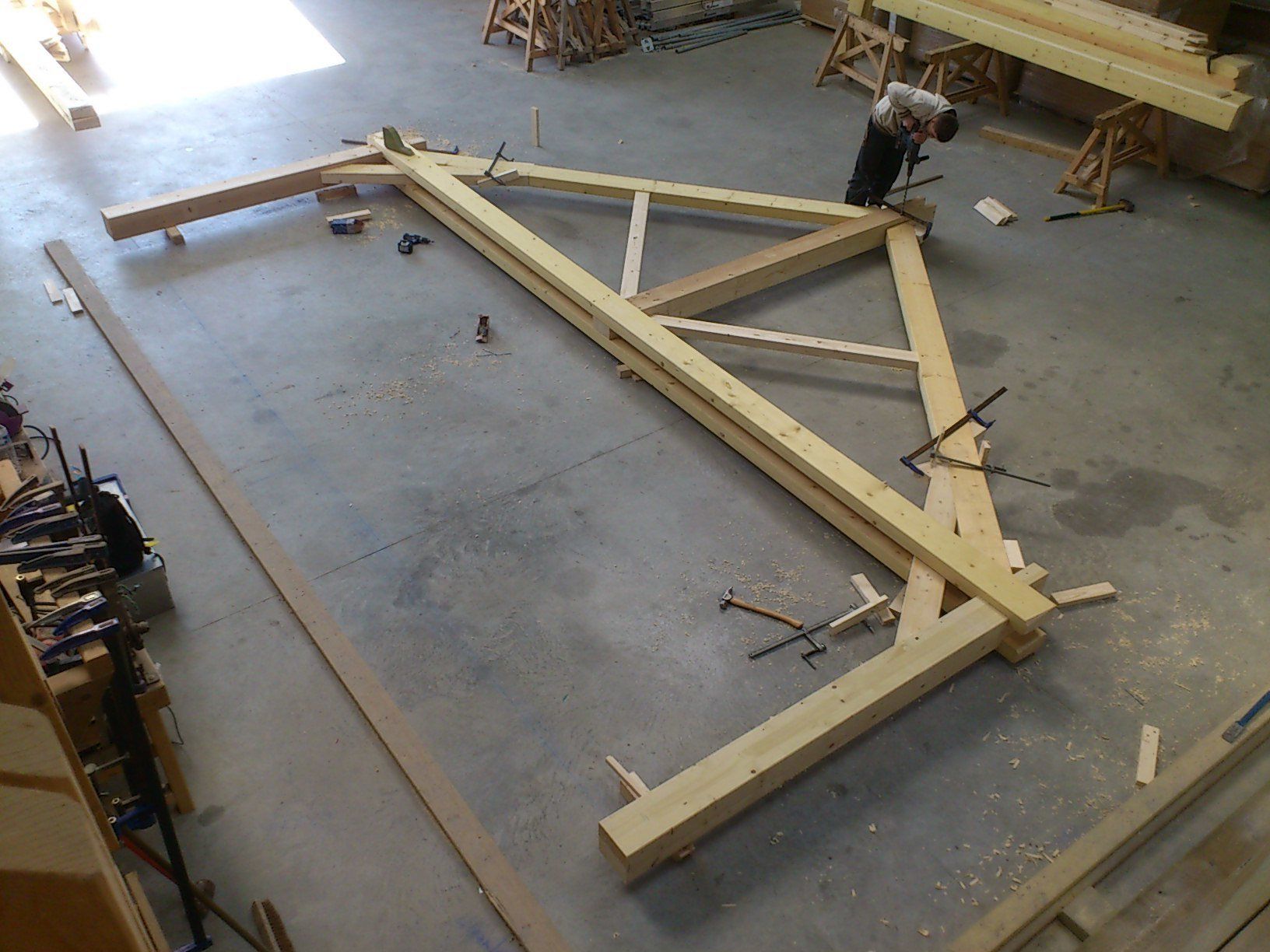 Réalisation la ferme d'une charpente en bois posée à plat sur le sol