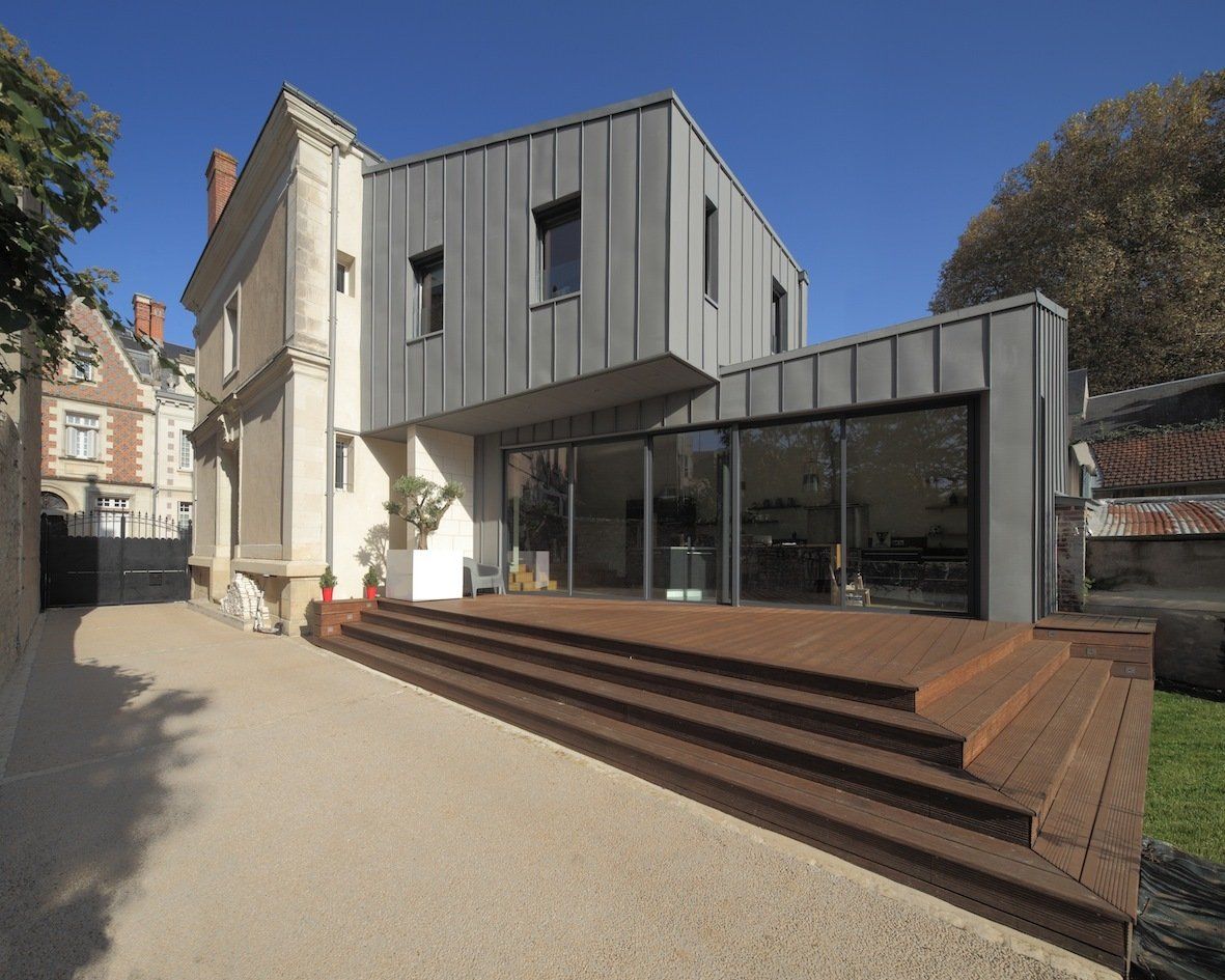 Terrasse avec marches en bois devant une très grande baie vitrée