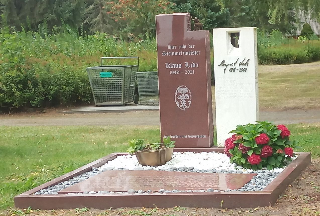 Ein Grab auf einem Friedhof mit einem Kreuz darauf