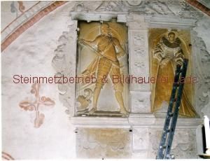 An einer Wand neben einer Leiter steht die Statue eines Mannes in Ritterrüstung.