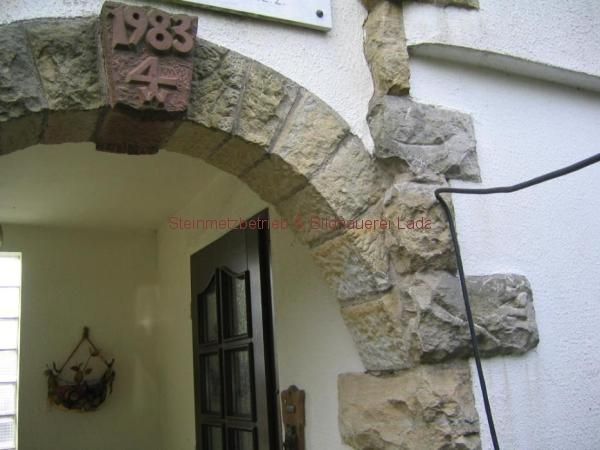 Ein steinerner Torbogen mit der Jahreszahl 1983 darauf