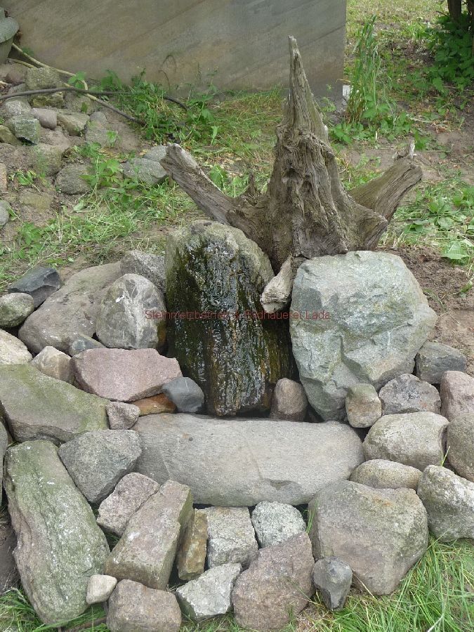 Ein Steinhaufen mit einem Baumstumpf in der Mitte