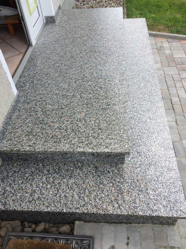 Eine Reihe Granitstufen führt zu einem Haus hinauf.