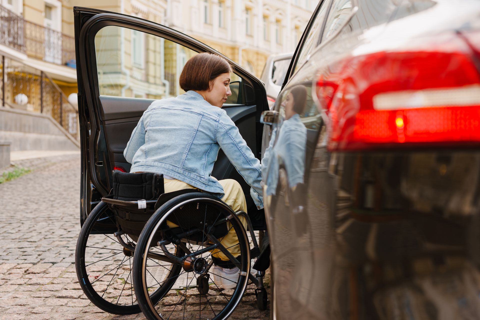 Une personne handicapée et une voiture noire.