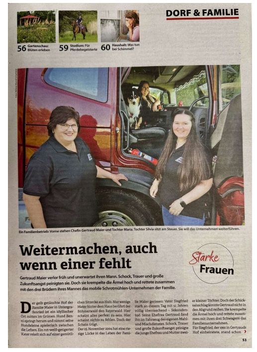 Two women, one in cab, pose with truck. Text 