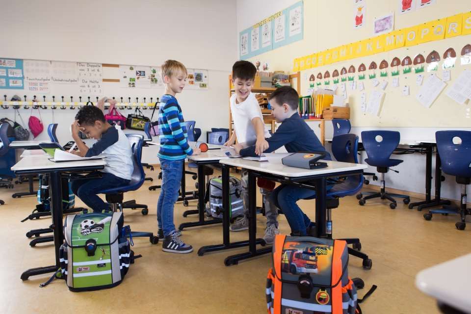 Kinder in der Schule mit ihren Rucksäcken