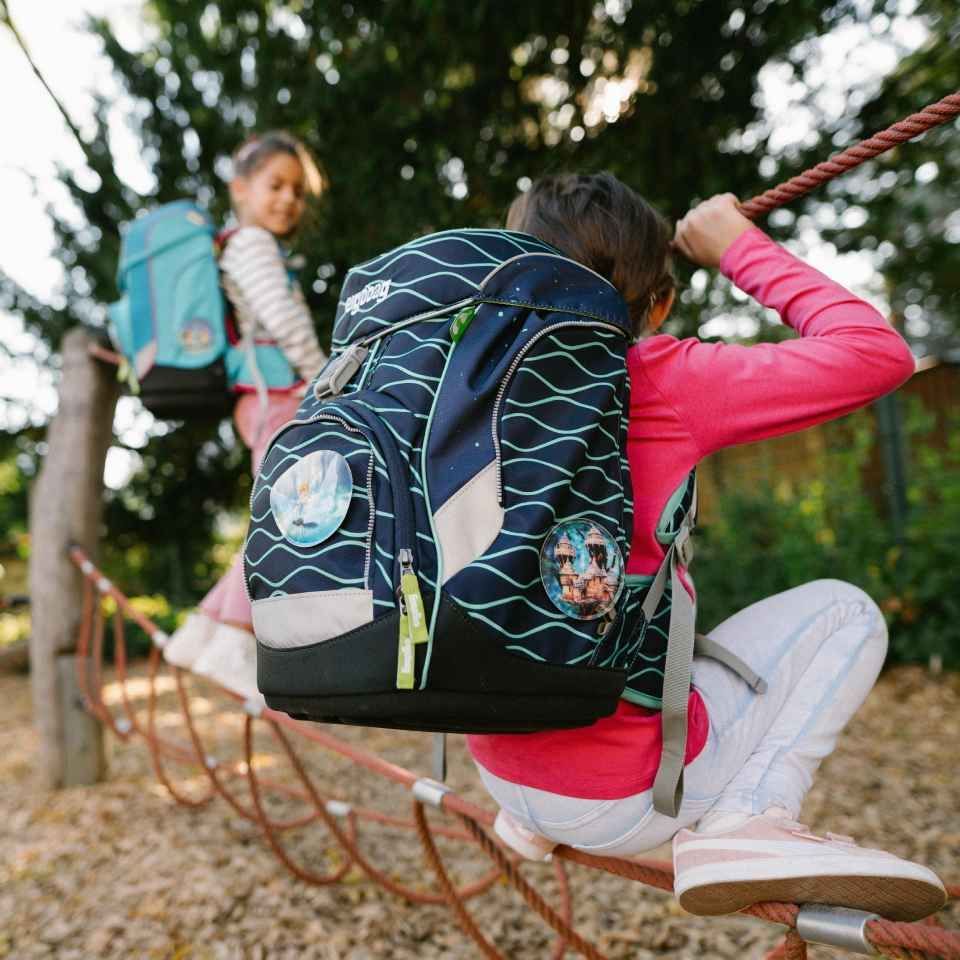 Kind mit Rucksack auf dem Rücken beim Klettern