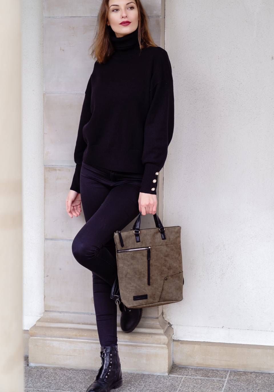 Schwarz angekleidete Frau mit Ledertasche