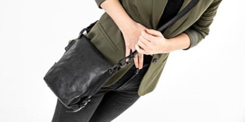 Frau mit einer schwarzen Tasche an der Hüfte