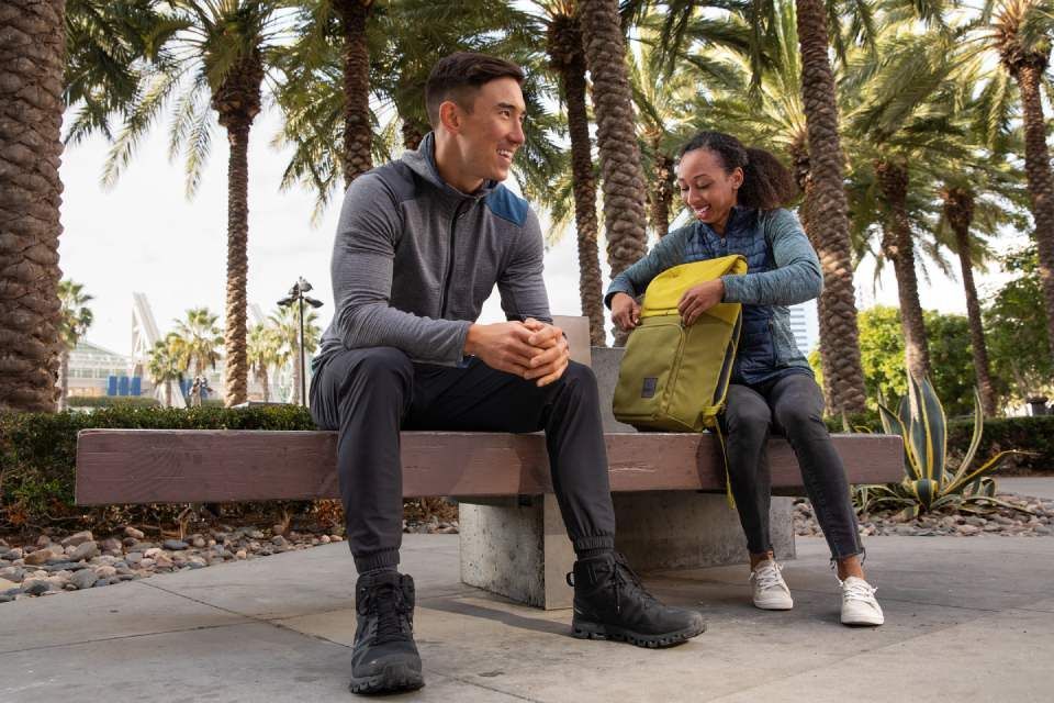 Zwei Personen sitzen und haben eine Tasche