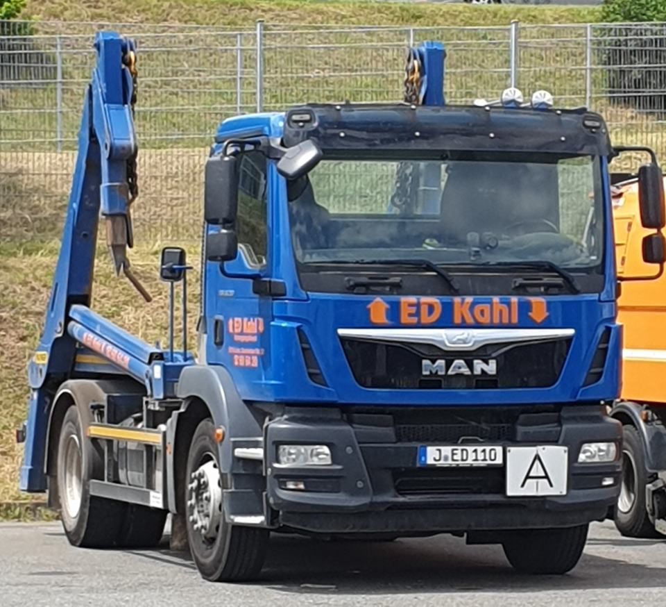 Ein blauer MAN-Abschleppwagen mit orangefarbenem „ED Kahl“-Schriftzug auf dem Fahrerhaus parkt im Freien.