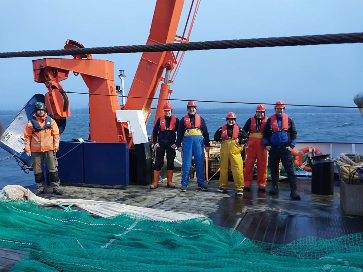 Eine Gruppe Männer steht auf einem Boot im Meer.
