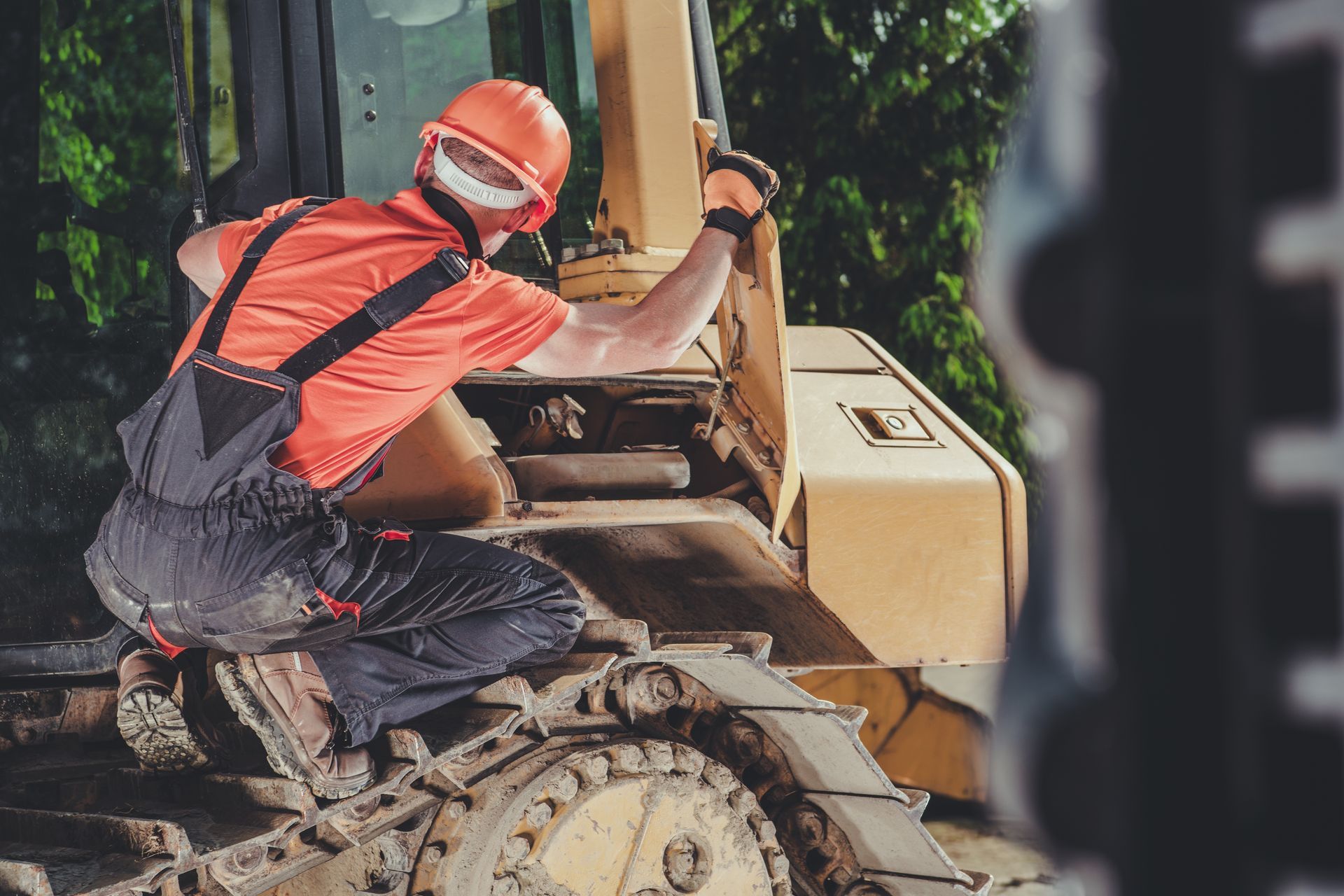 Un homme réalise le dépannage d'un engin de chantier sur site