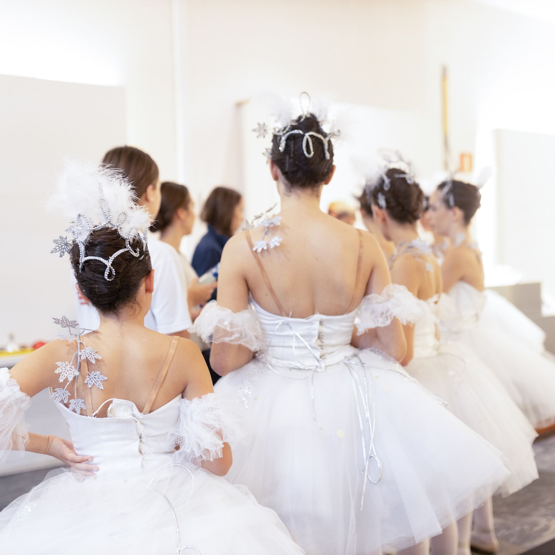 Un grupo de mujeres con vestidos blancos están de pie en una habitación.
