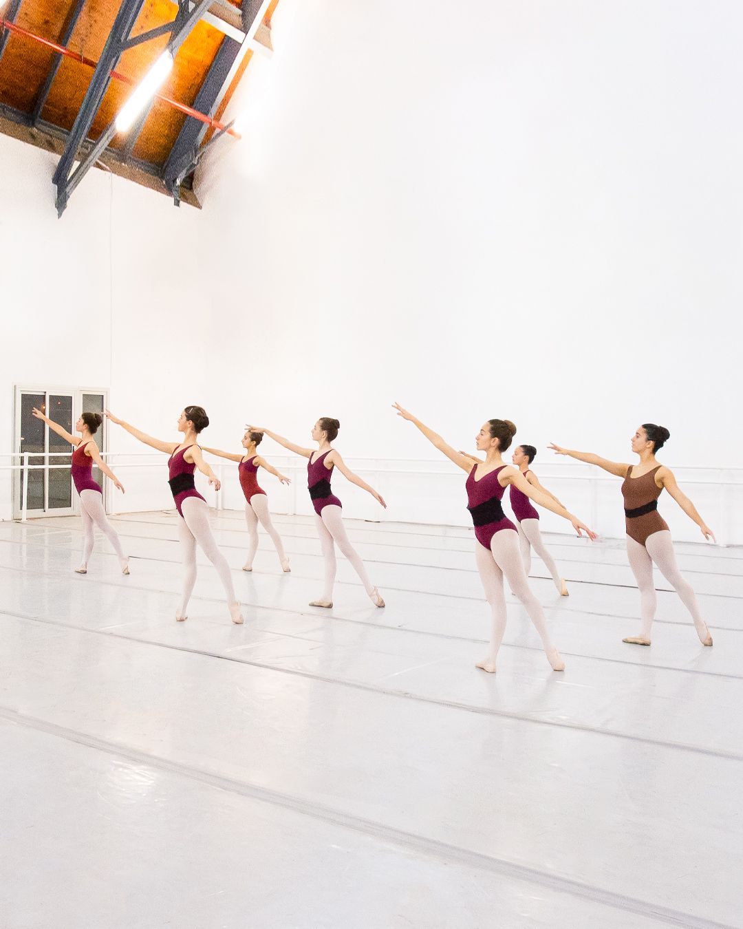 Un grupo de mujeres jóvenes están bailando en un estudio de baile.