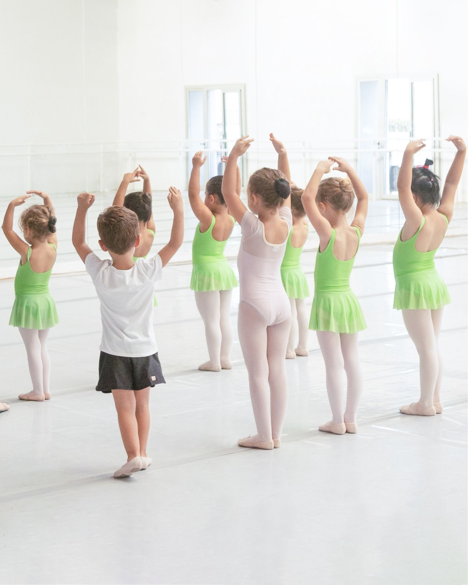 Un grupo de chicas jóvenes están practicando ballet en un estudio de baile.