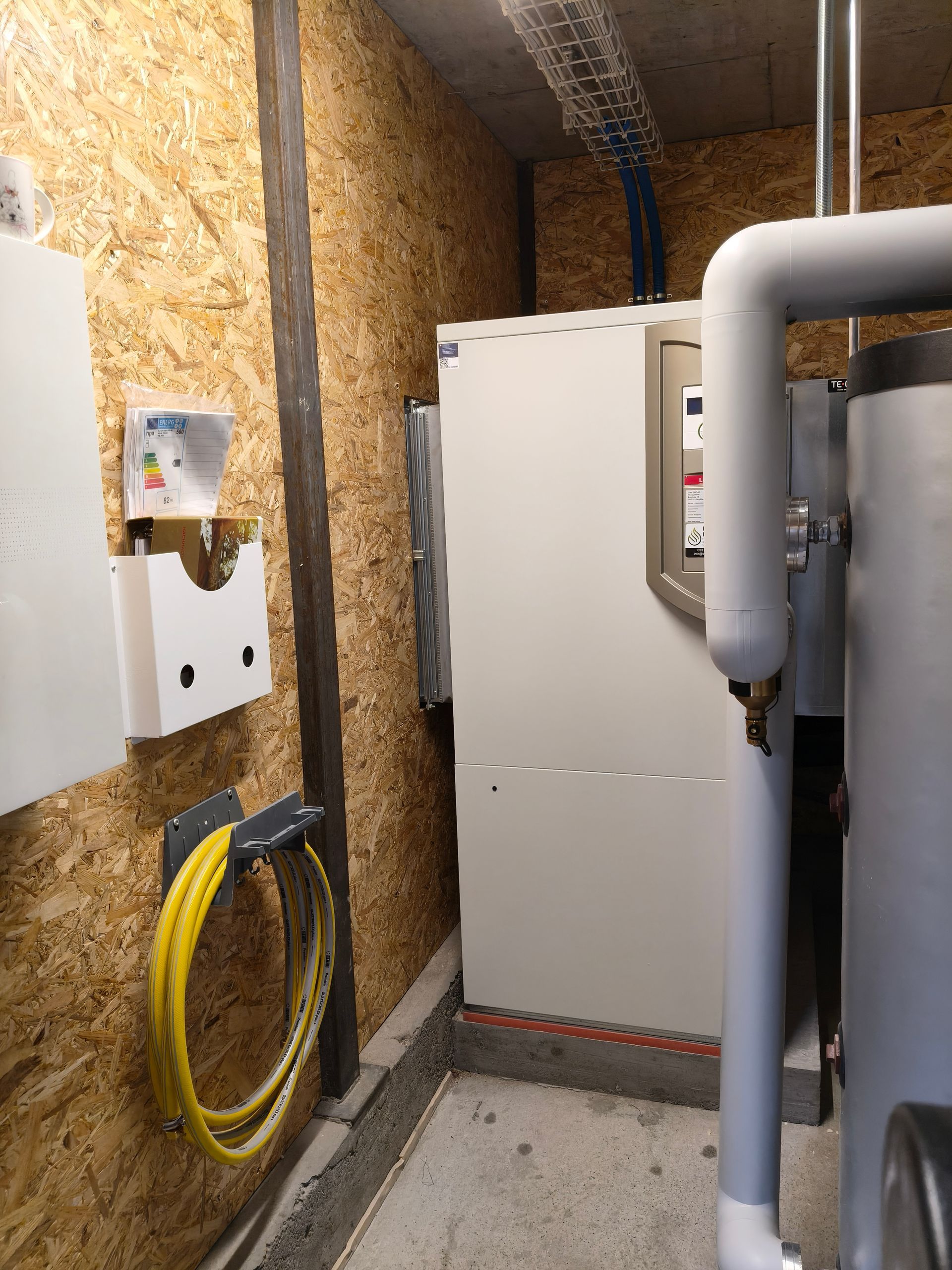 Architekt arbeitet an Bauplänen mit digitaler Schnittstellenüberlagerung und Schutzhelm.