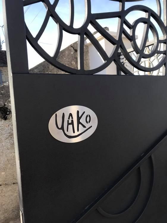 Portail en fer forgé estampillé Yako Architecture.