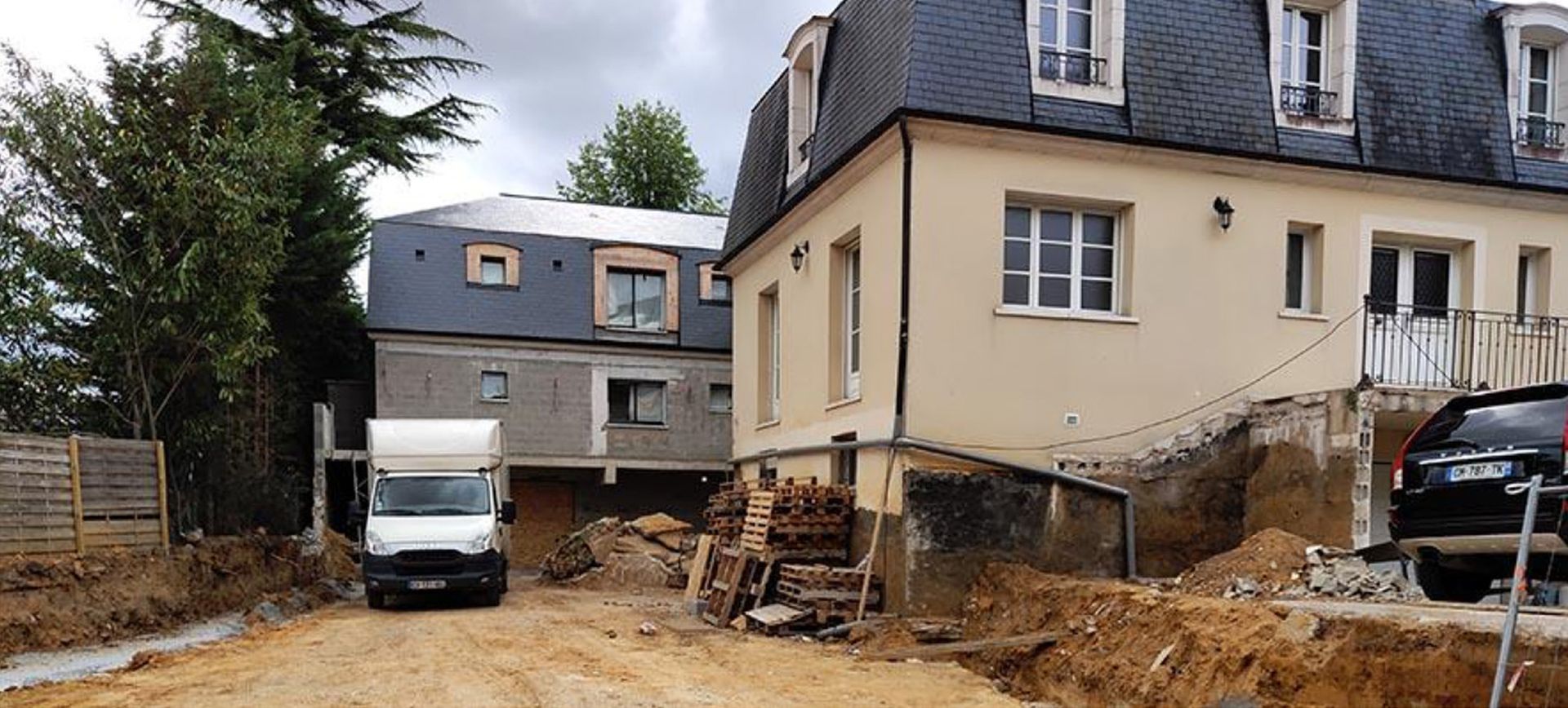 Camionnette garée à proximité de bâtiments en cours de travaux.
