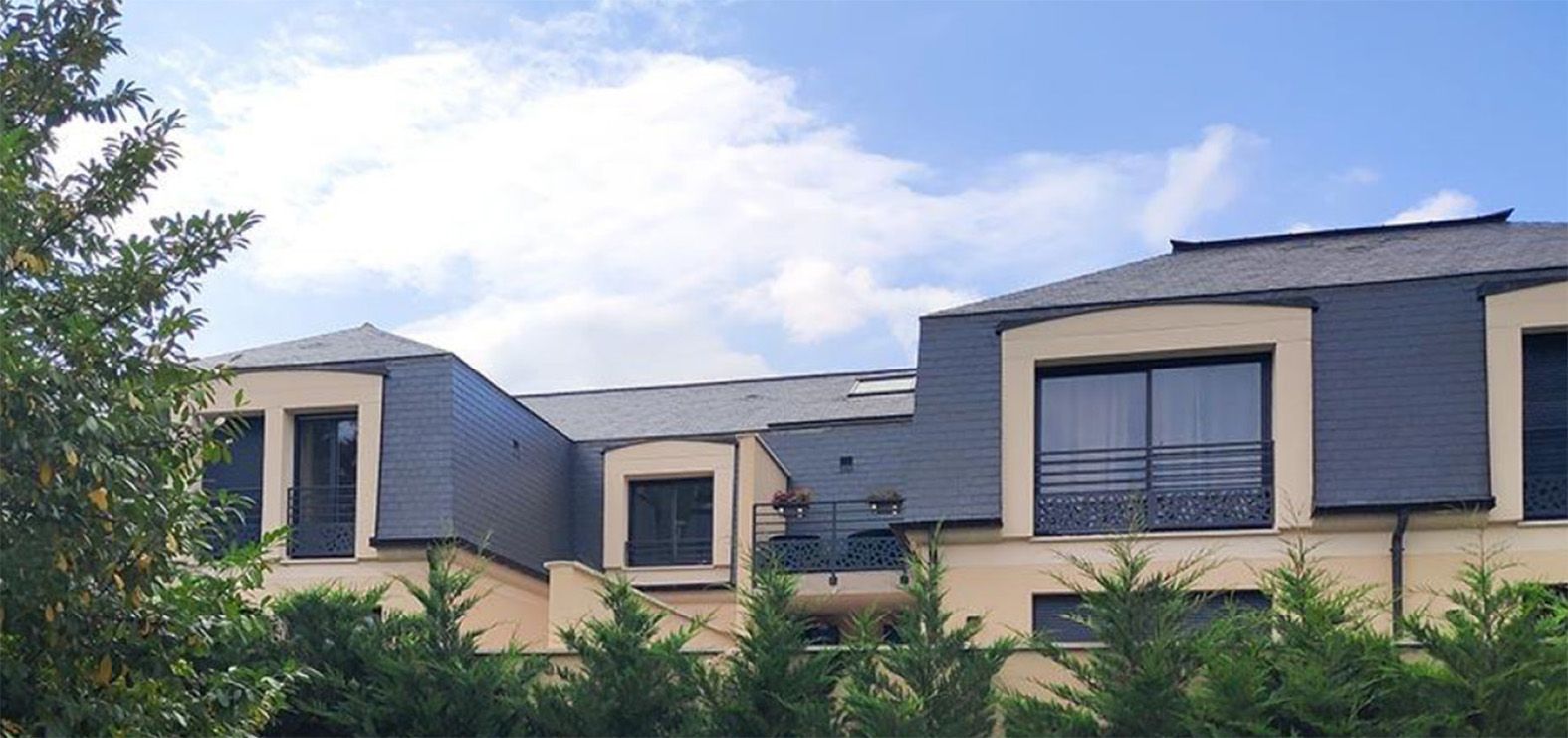 Partie supérieure des logements dépassant les arbustes environnants.