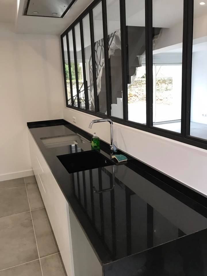 Grand plan de travail dans une cuisine ouverte sur une autre pièce.