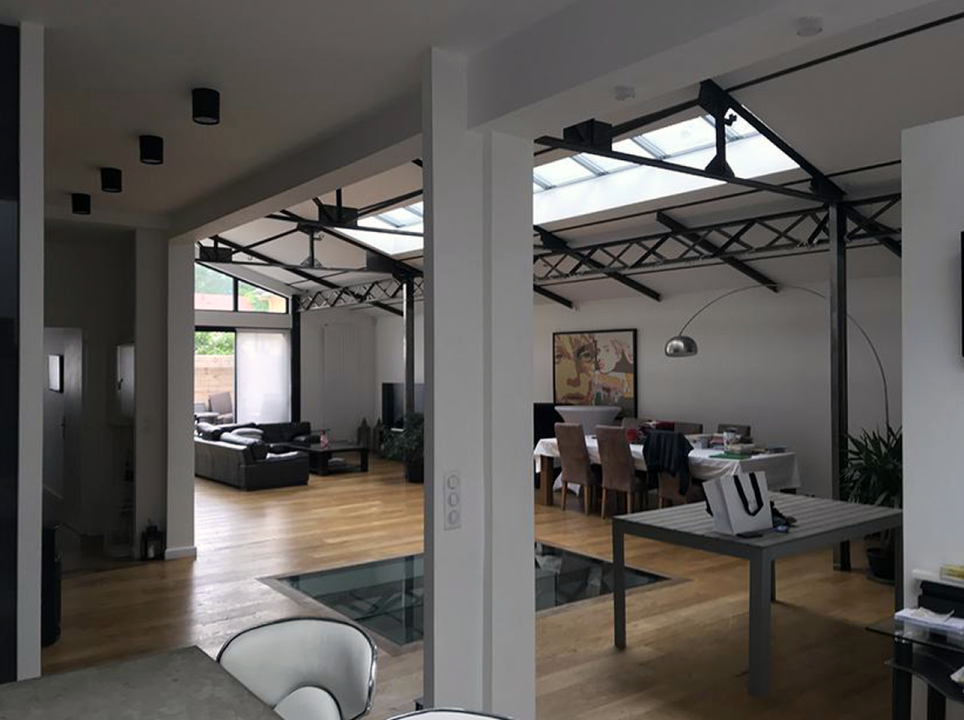Grand intérieur d'un loft meublé de sièges, tables, sièges et canapé.