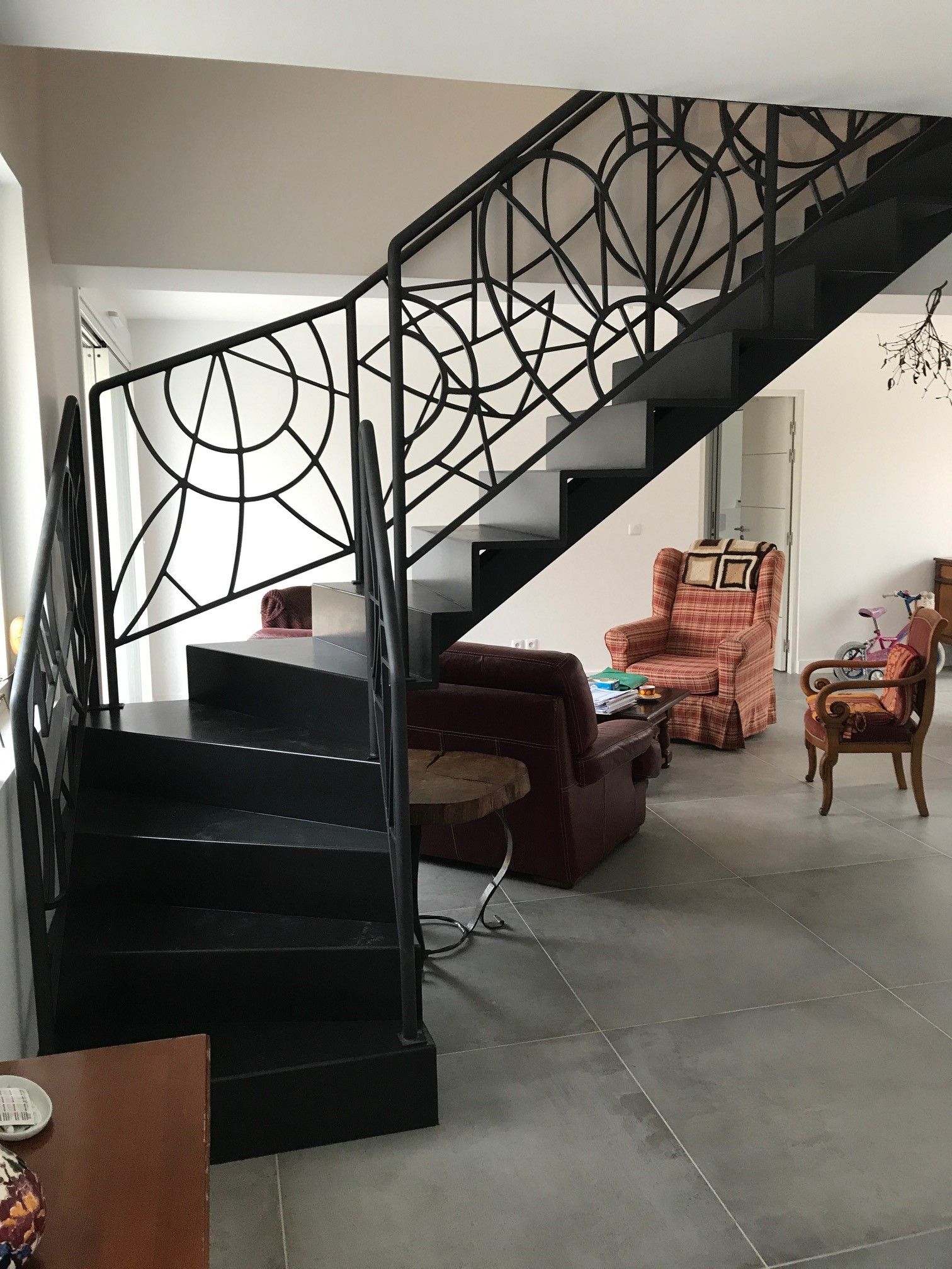 Escalier noir aux rambardes design dans une pièce de vie.