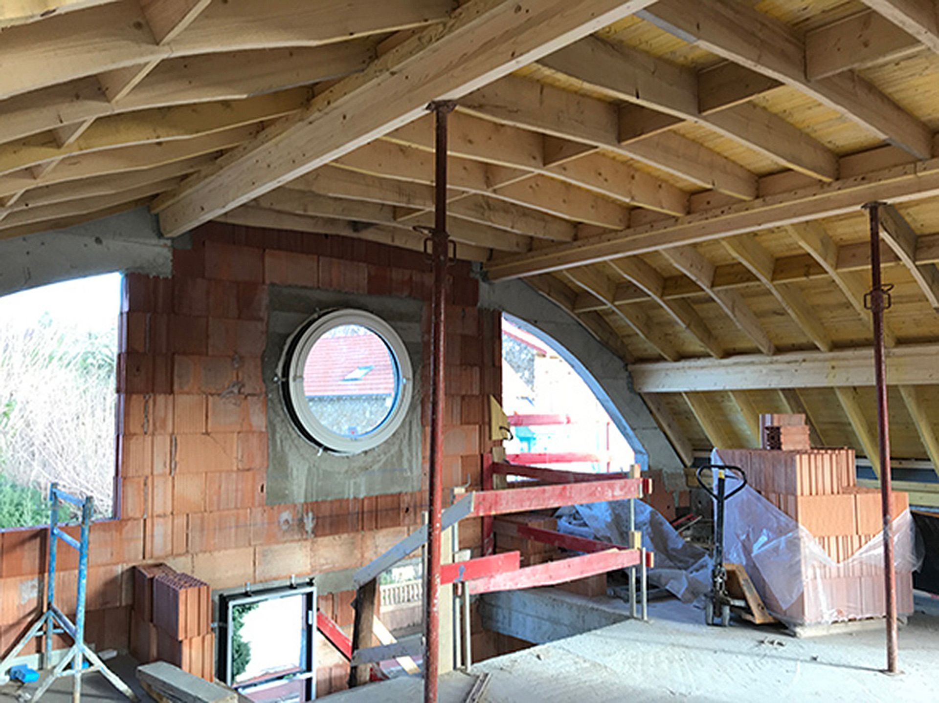 Intérieur d'une ossature en bois et toit cintré en cours de conception.