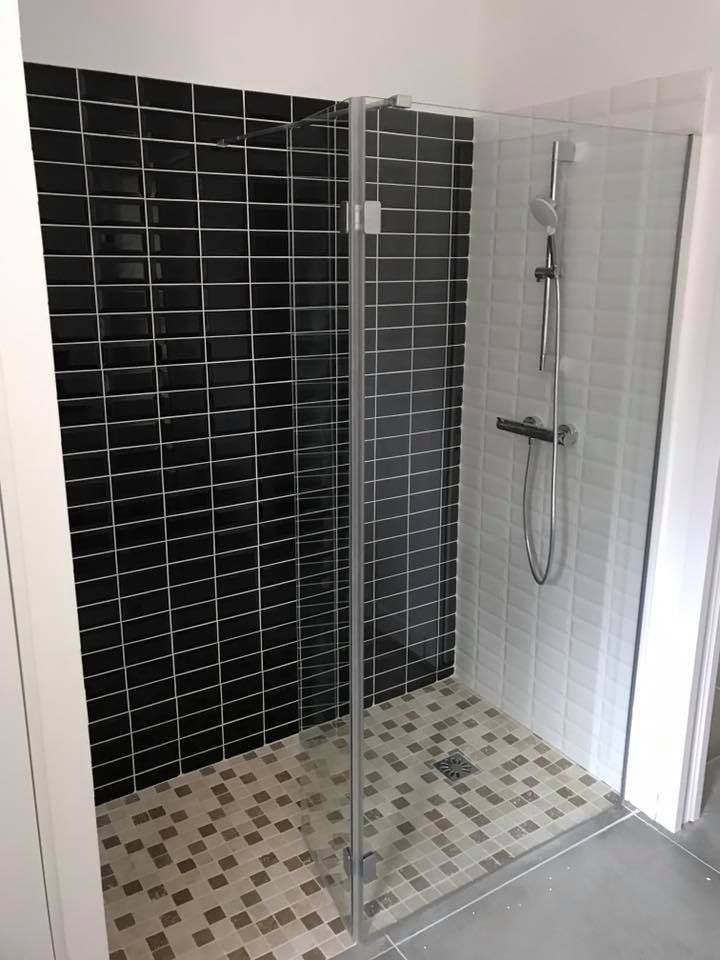 Cabine de douche entièrement carrelée.