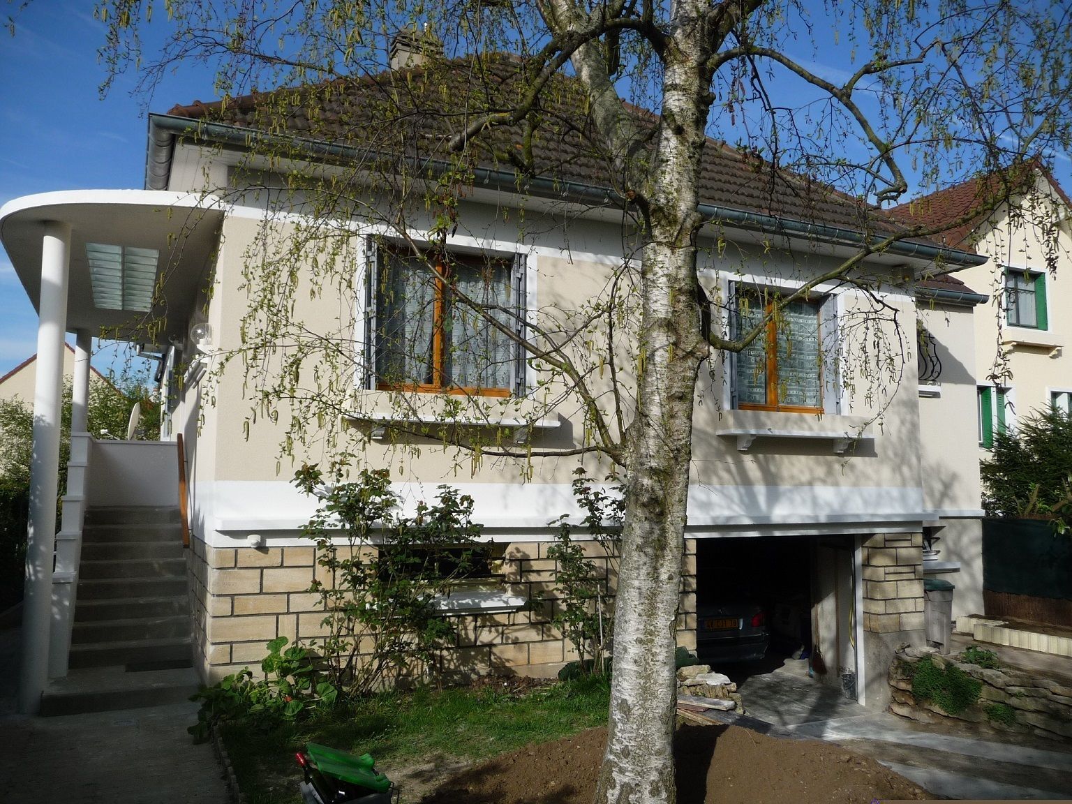 Maison surélevée avec un accès par un escalier protégé des intempéries.