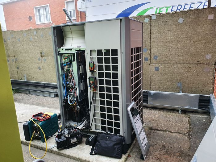Armoire électrique ouverte avec câblage et équipement à côté d'un mur de briques à l'extérieur