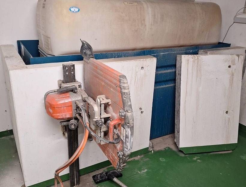 In einem Raum schneidet eine Maschine ein Stück Holz.