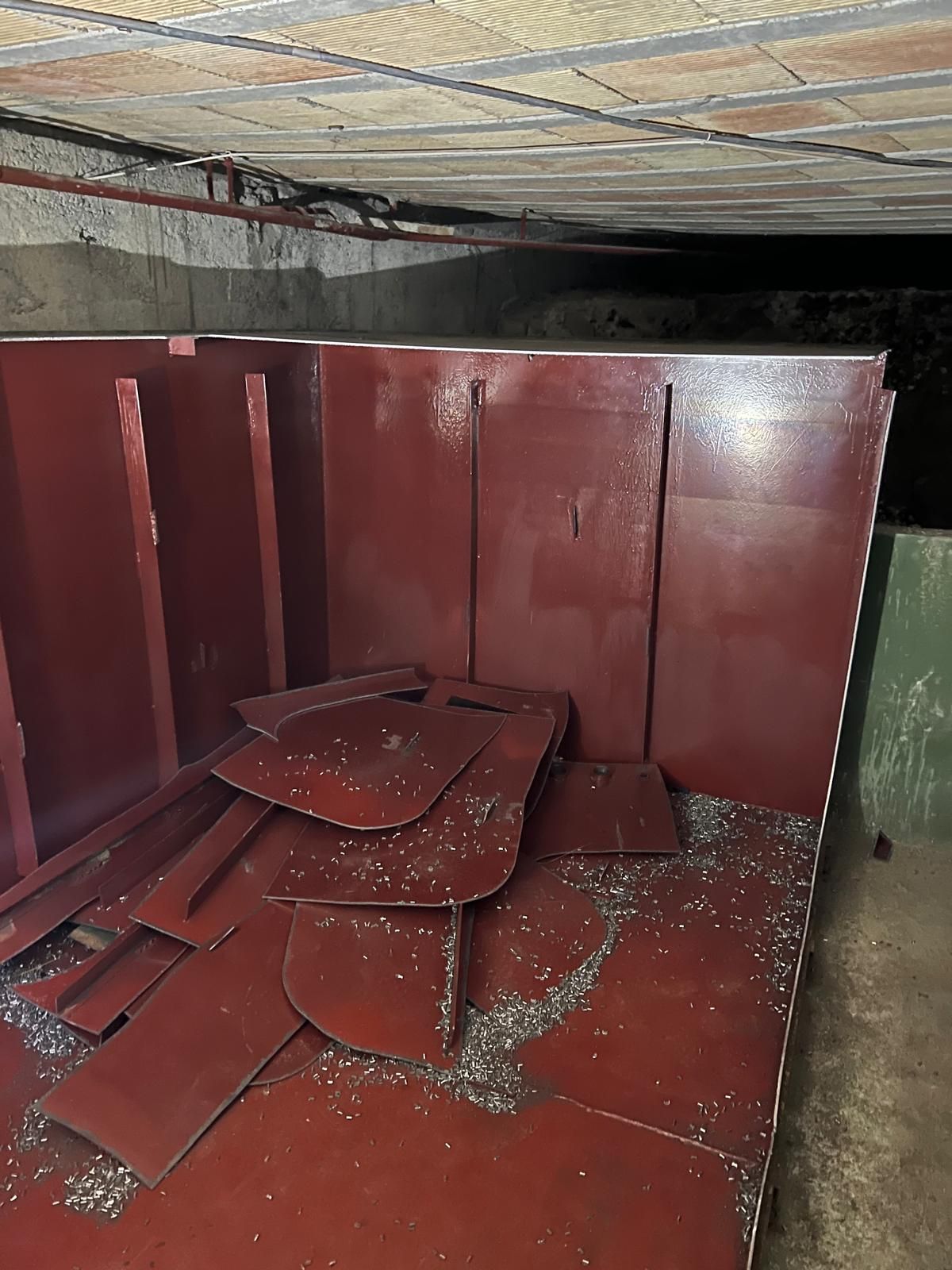 In einem dunklen Raum steht ein großer schwarzer Tank.