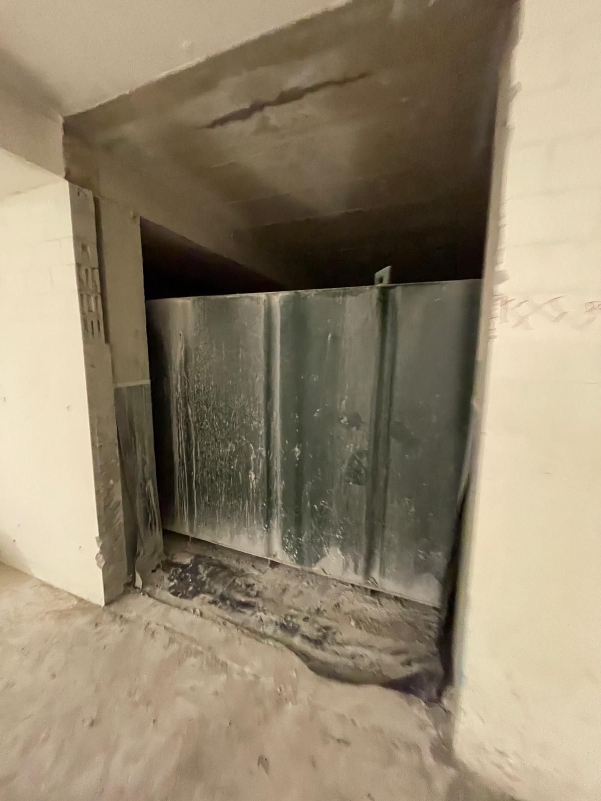 In einem dunklen Raum steht ein großer schwarzer Tank.