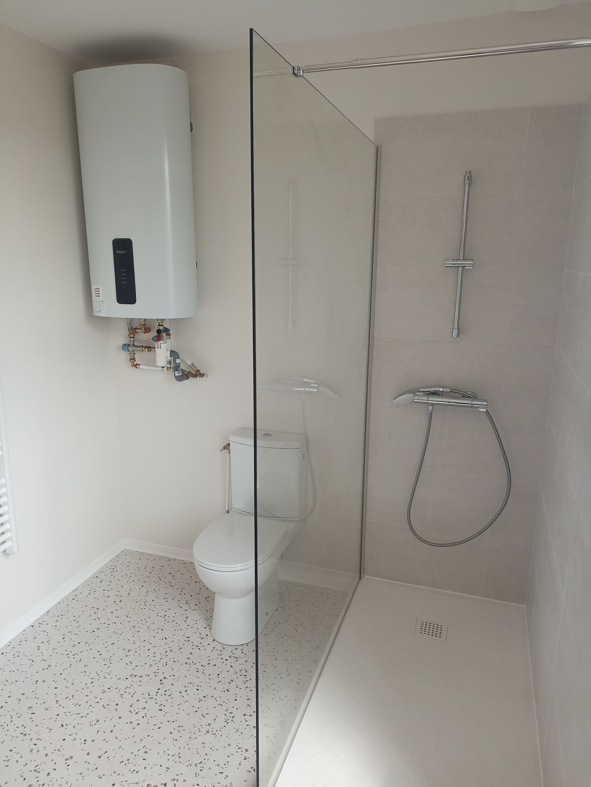 Salle de bains accessible avec douche à l'italienne, WC, lavabo et paroi de douche rabattable